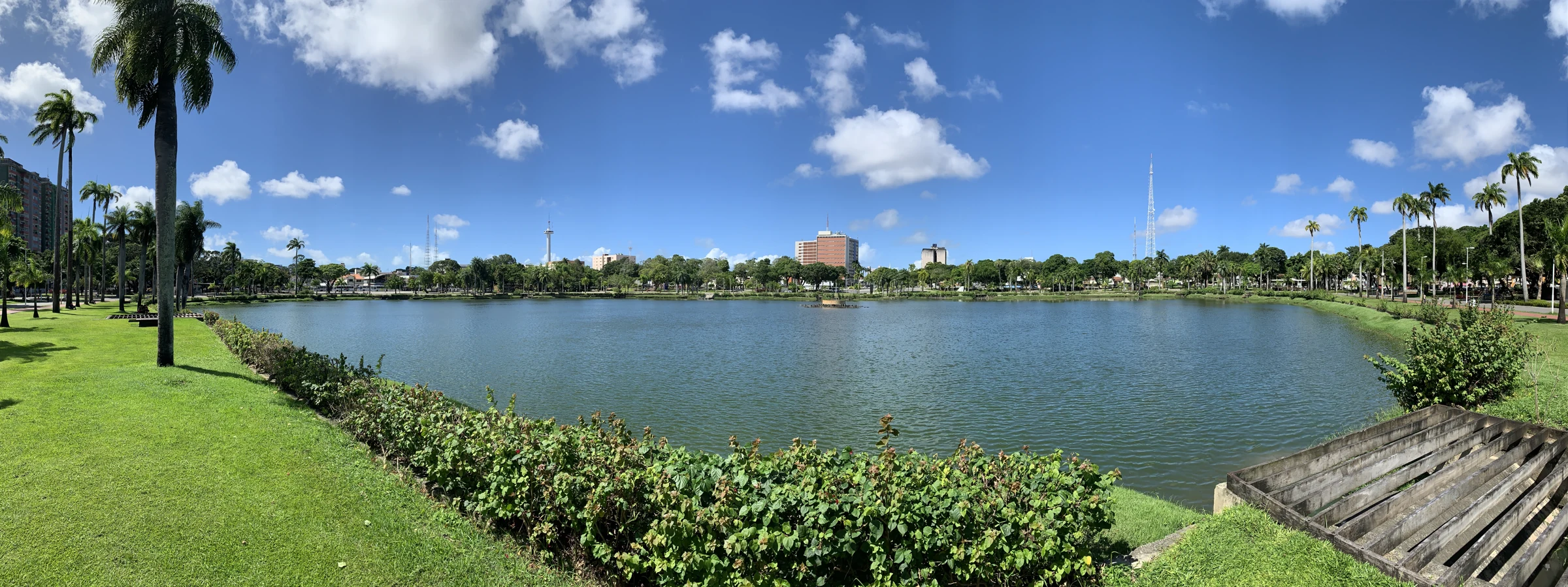 Vista panorâmica do Parque da Lagoa Solón de Lucena, com espelho d'água, palmeiras e o horizonte de João Pessoa